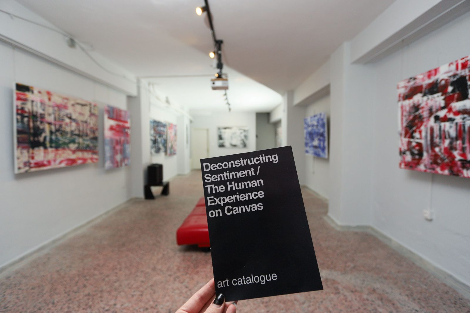 The Deconstructing Sentiment art catalogue held up in the gallery